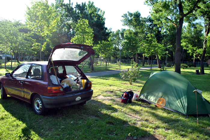 Das hinten offene Auto, Sternchen genannt, neben dem Zelt auf einer Zeltplatzwiese unter Bäumen